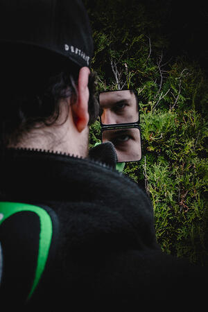 Man staring into mirror eye reflected